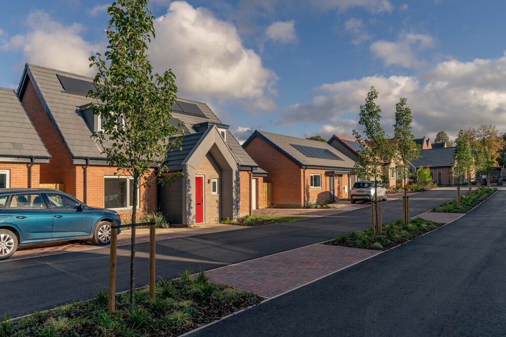 The exterior of two McCarthy Stone retirement bungalows, with trees lining the street of the house.