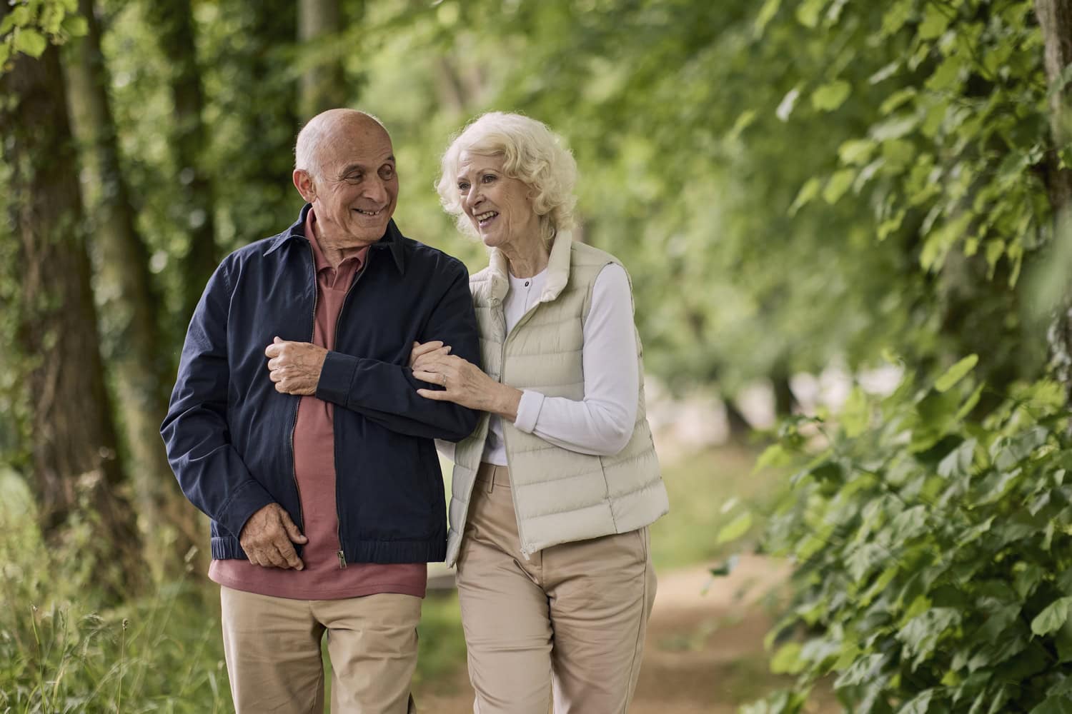 A man and woman walking and smiling enjoying retirement life