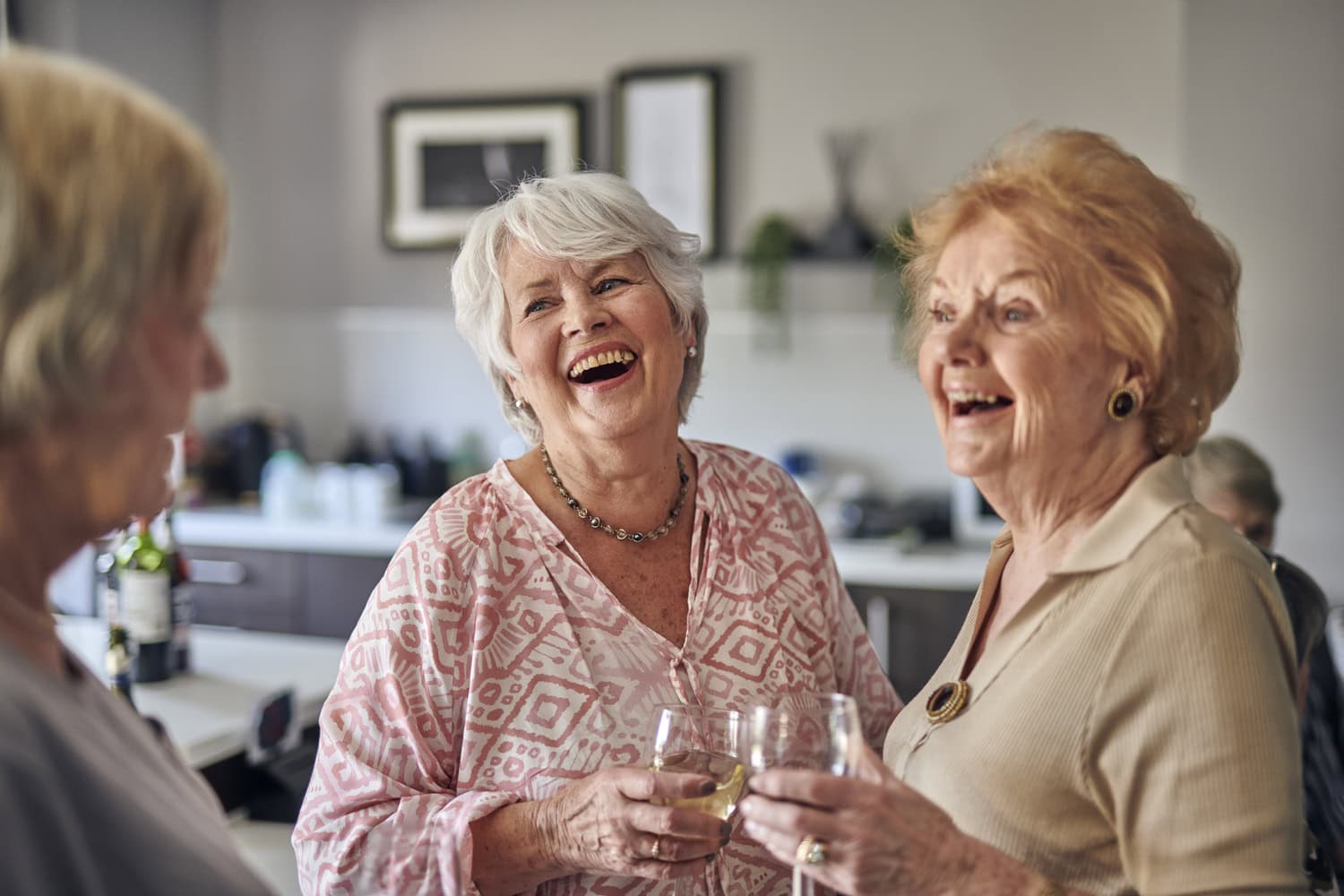 Ladies drinking and laughing together in independent living for over 60s