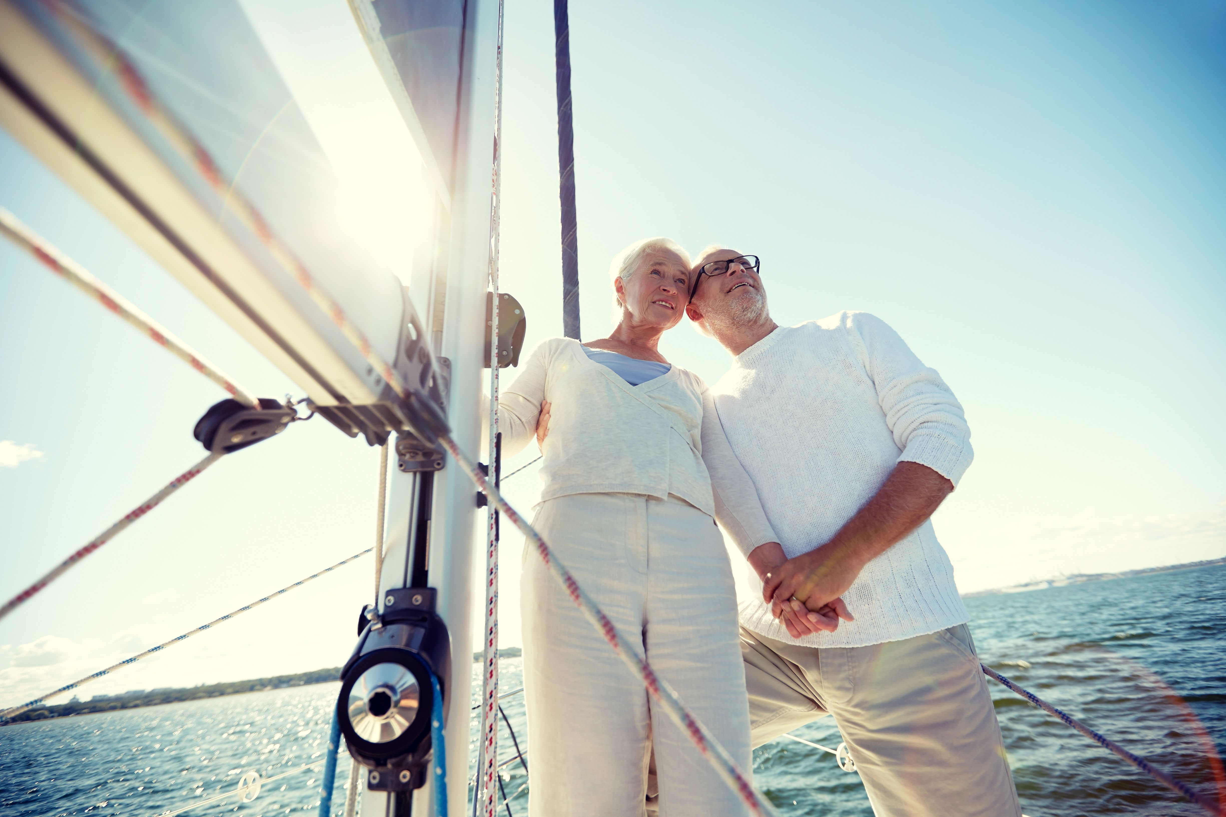 A retired couple on a sailing boat at sea, enjoying life in retirement
