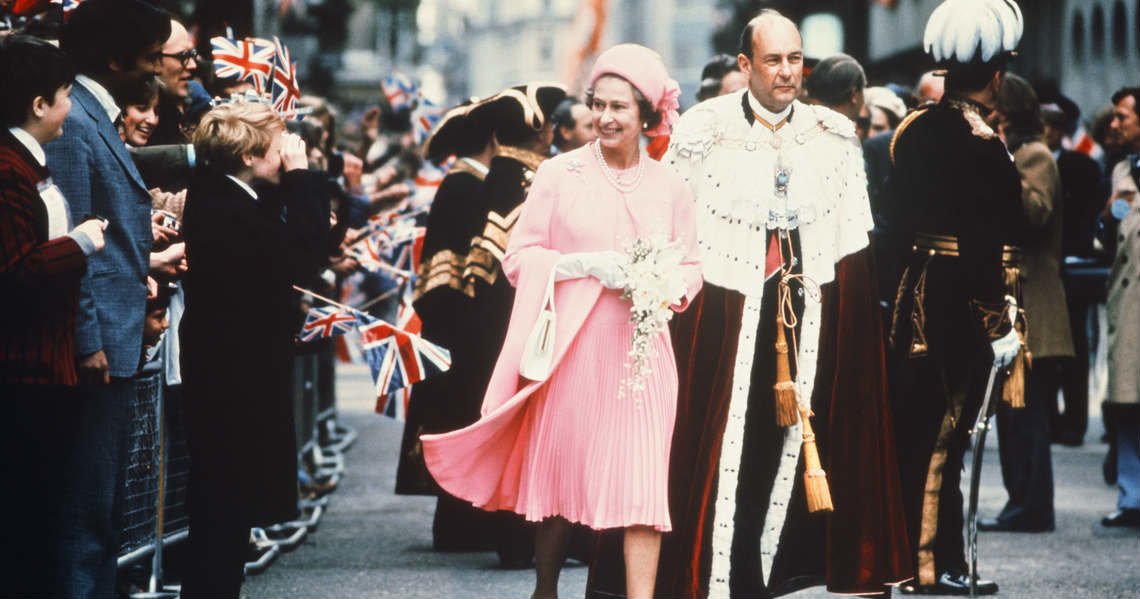 a man and woman in white robes walking in a crowd