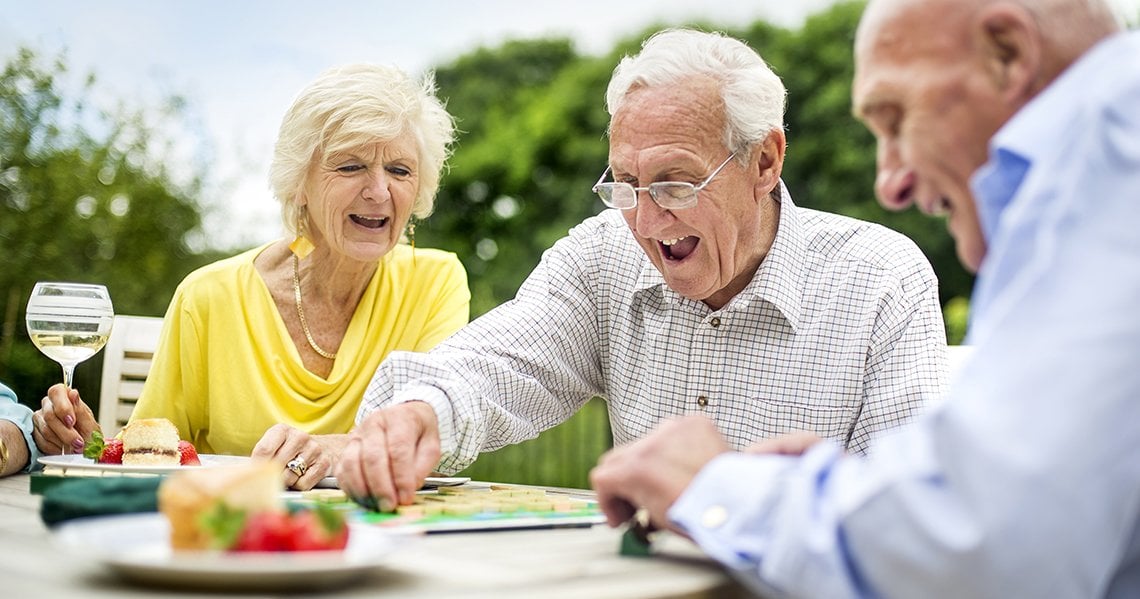 a group of people sitting at a table with food and drinks