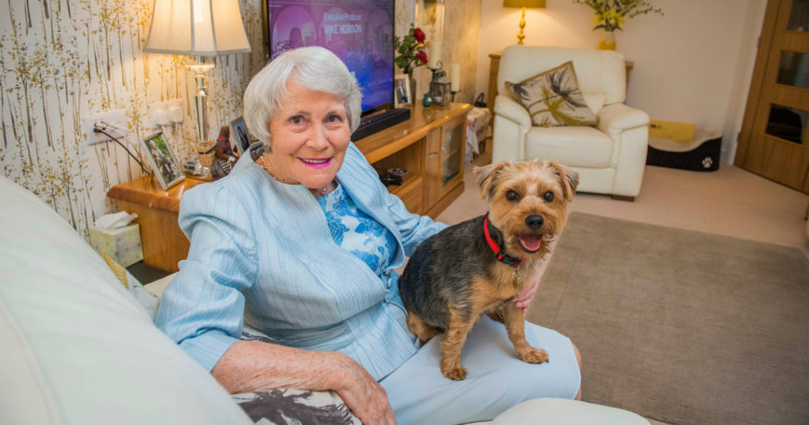 a person sitting on a couch with a dog