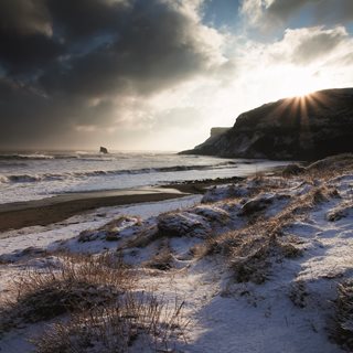 a snowy beach with a mountain in the background