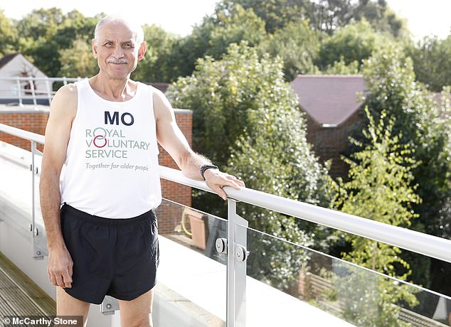 A McCarthy Stone homeowner and marathon runner poses beside a railing at his retirement home. The retiree wears a white running vest that reads: ‘Together for older people’