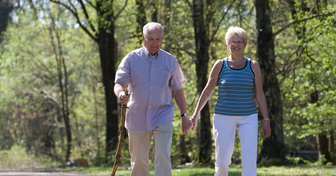 an old couple walking in the woods