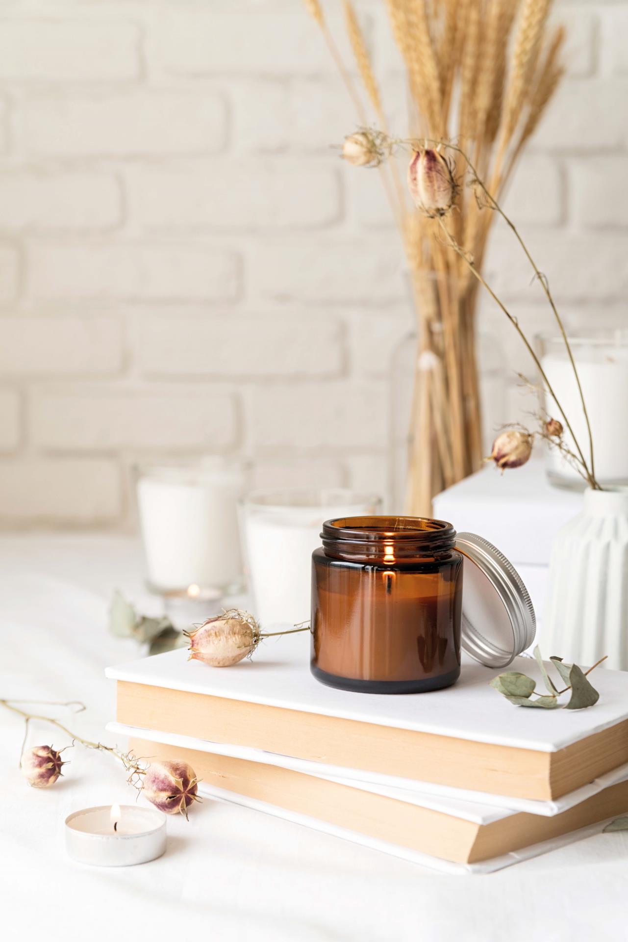A cream-coloured, homemade candle in a small jar with a lid
