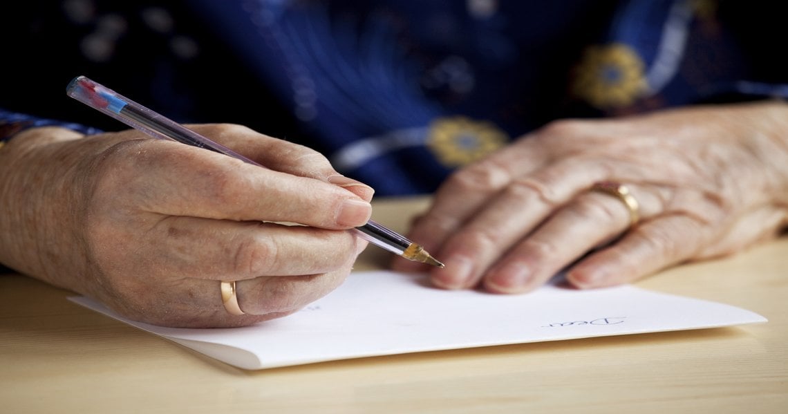 a person writing on a piece of paper