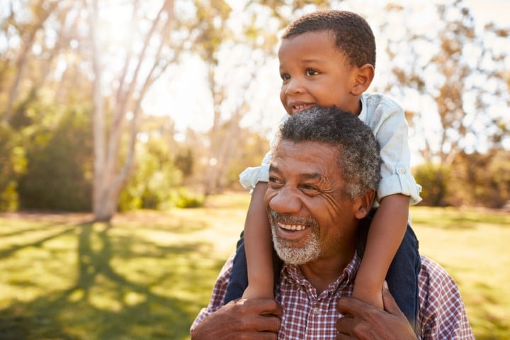 Grandad gives grandson a piggy back