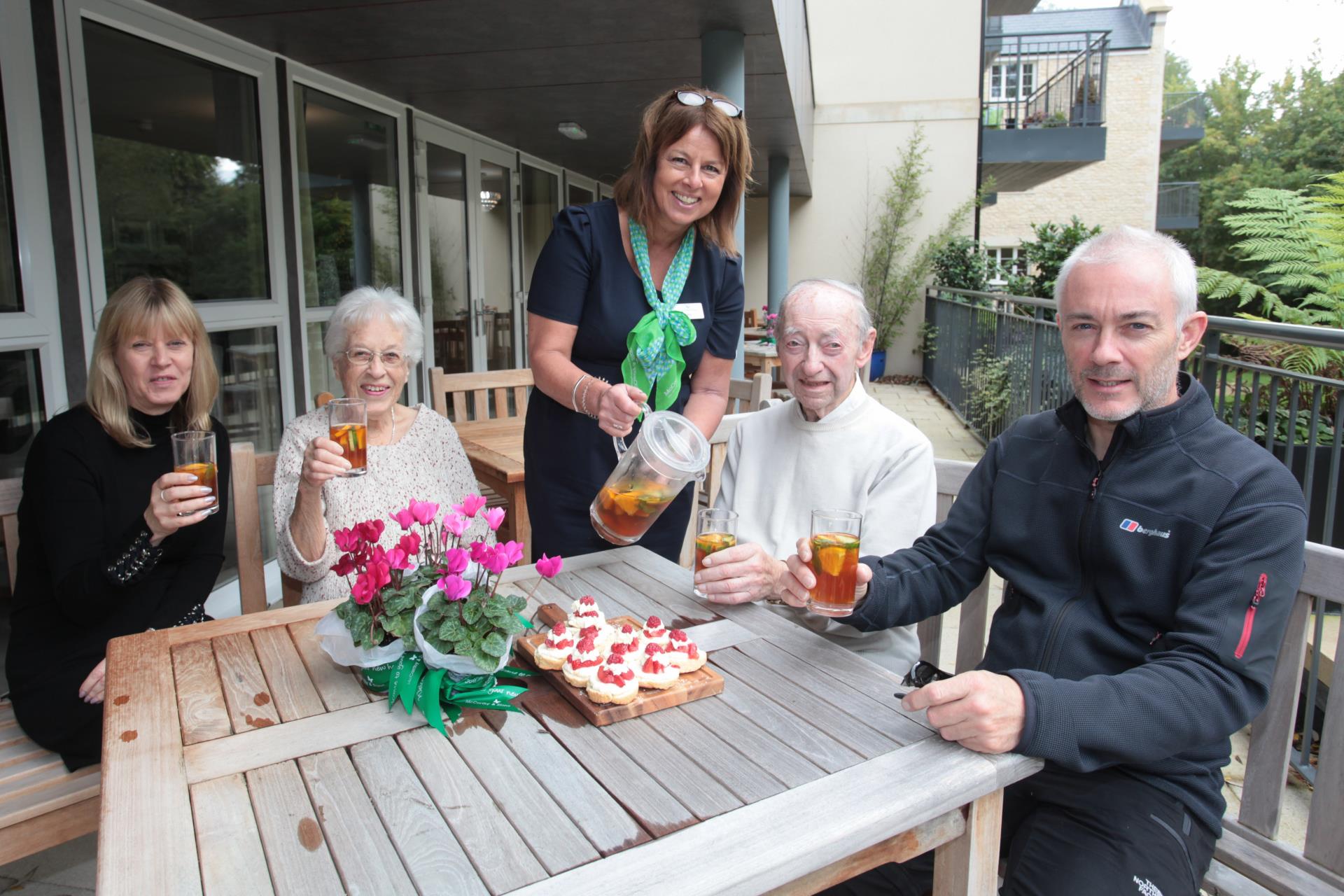 a group of people sitting around a table with food and drinks