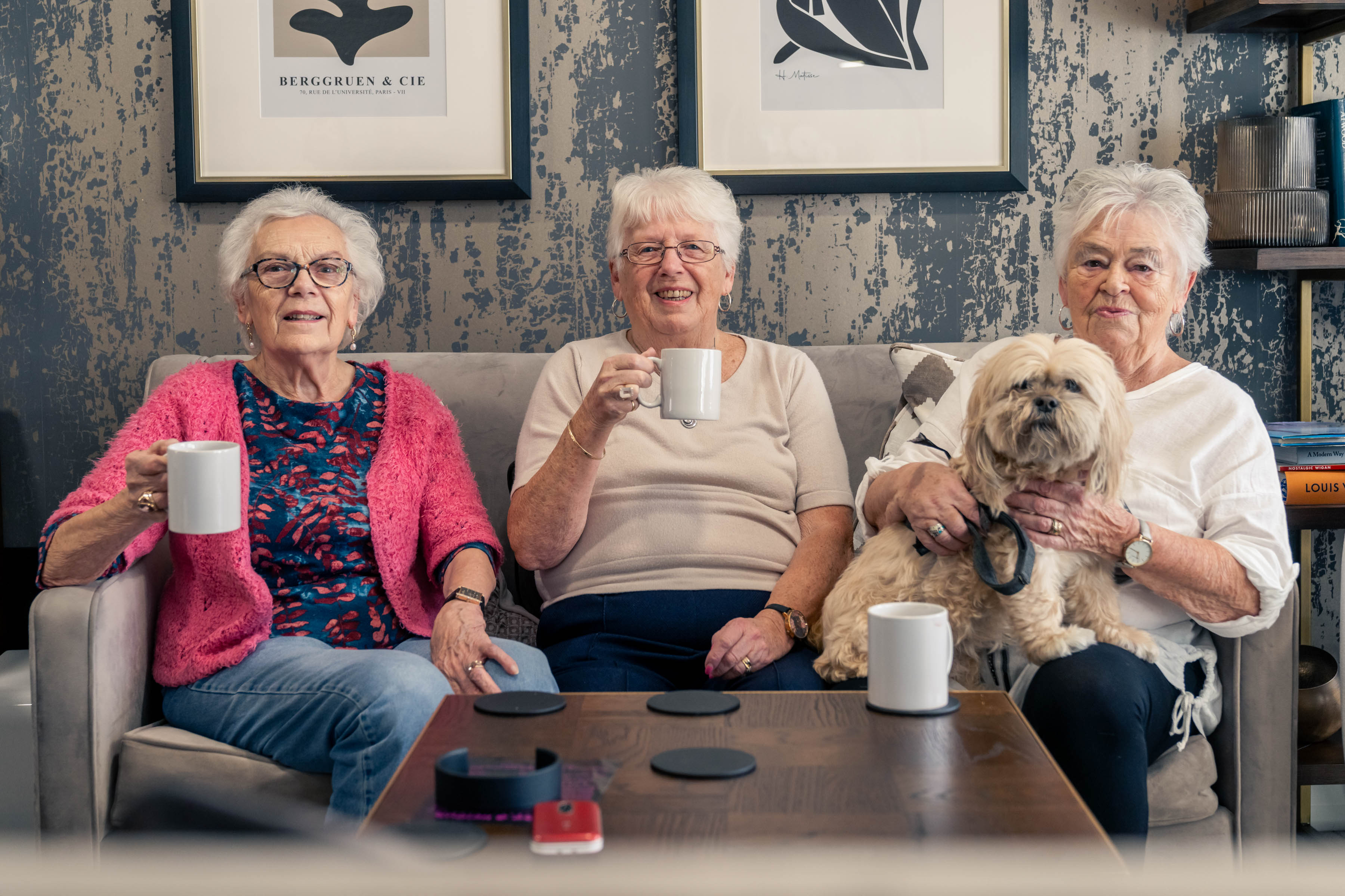 a group of women sitting on a couch with a dog