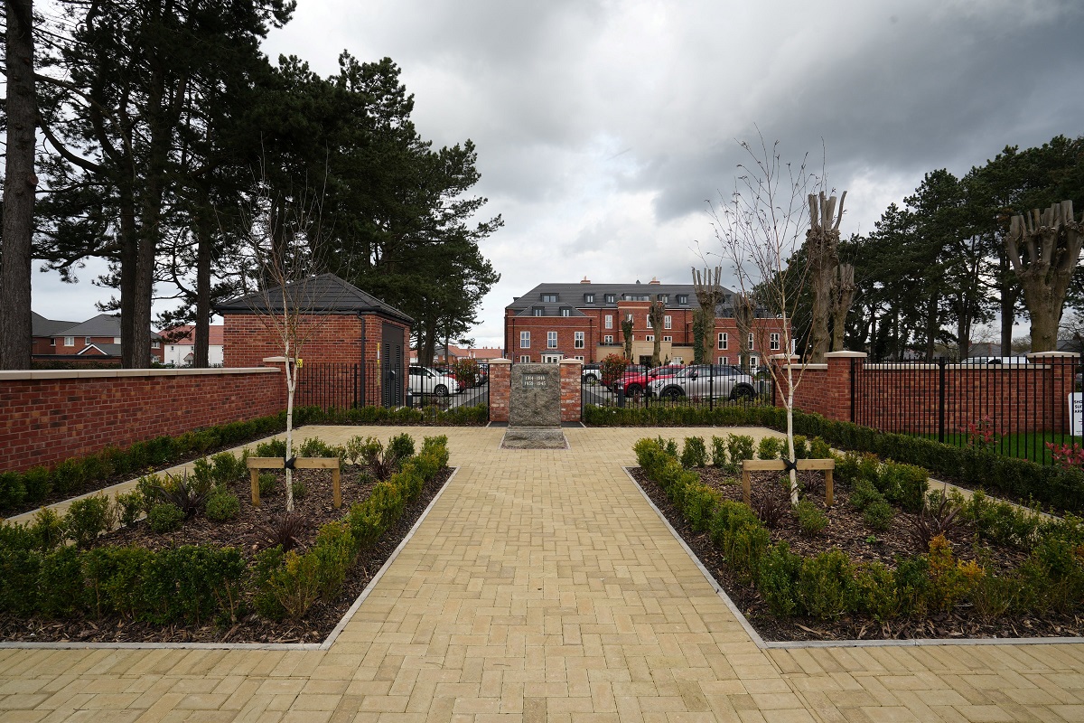 a brick walkway with a brick fence and a brick wall and trees