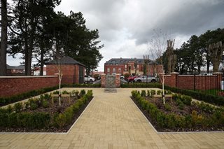 a brick walkway with a brick fence and a brick wall and trees