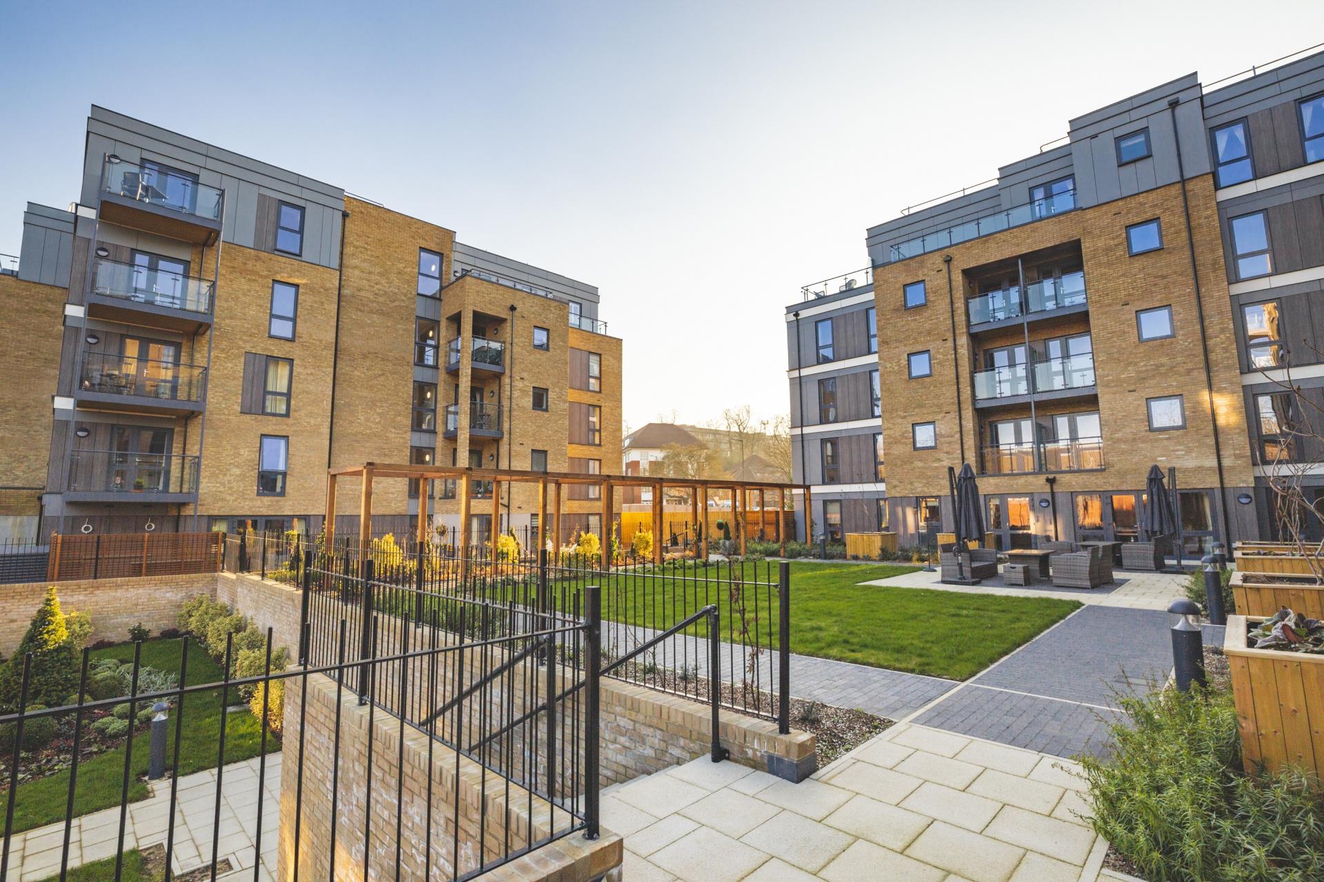 a fenced in courtyard with a building in the background