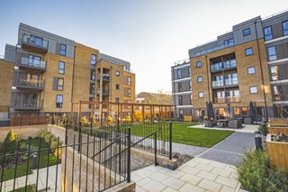 a fenced in courtyard with a building in the background