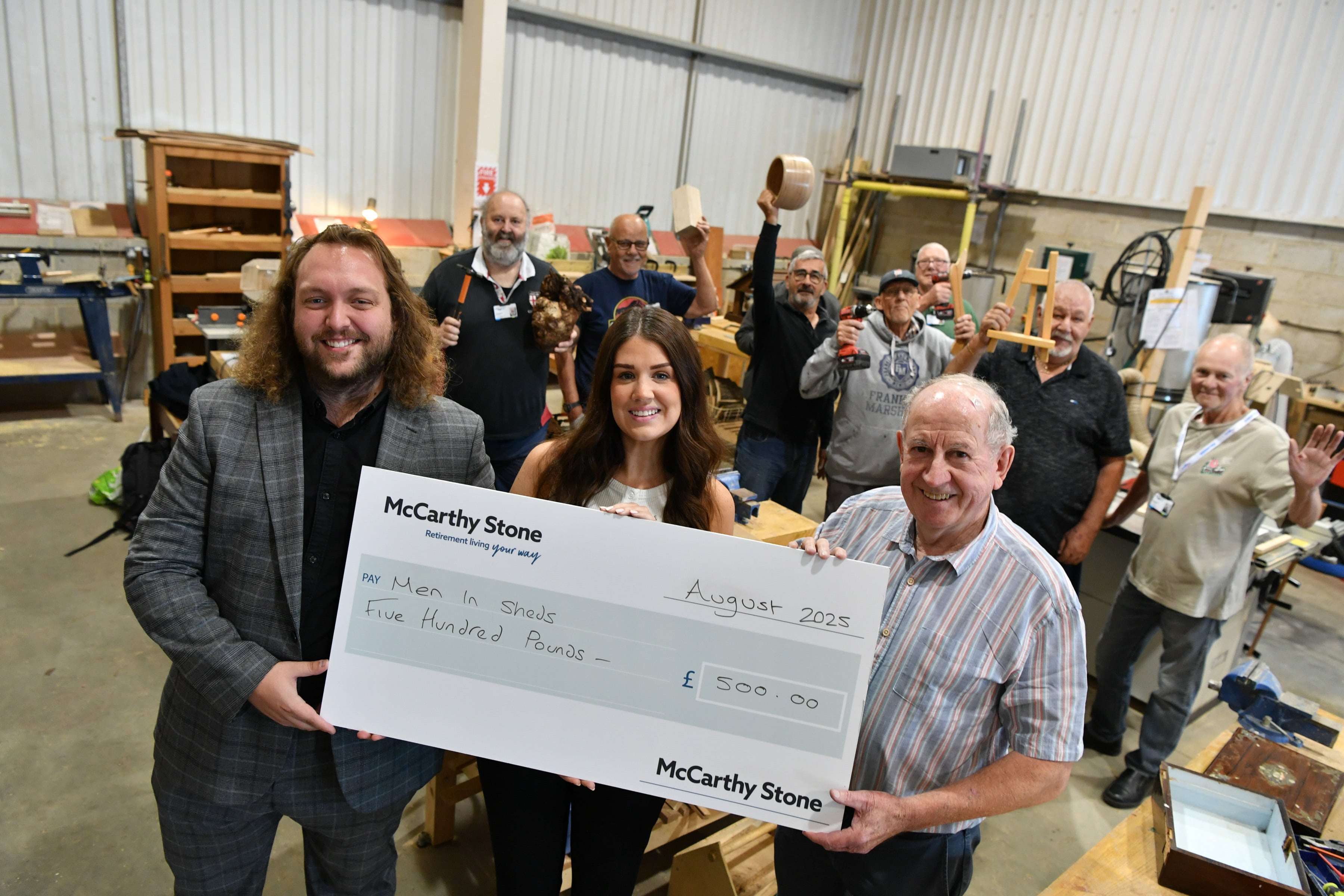 Staff from McCarthy & Stone present the Men in Sheds Group in Blidworth with a donation.