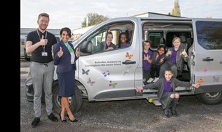 a group of people standing next to a van