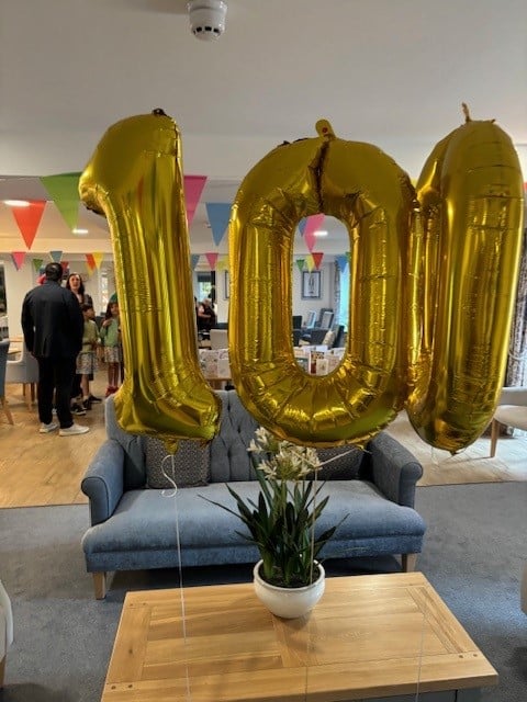 A 100th birthday balloon in the shared lounge of a Retirement Living PLUS development