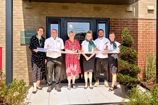 A group of McCarthy & Stone staff and the local Mayor cutting a ribbon in front of Harbourside House.