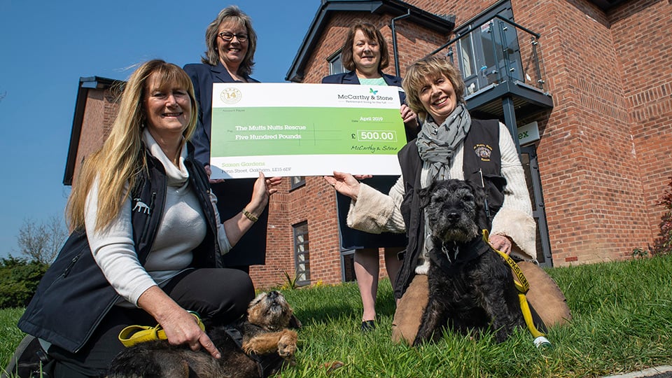 a group of women posing for a photo with a dog