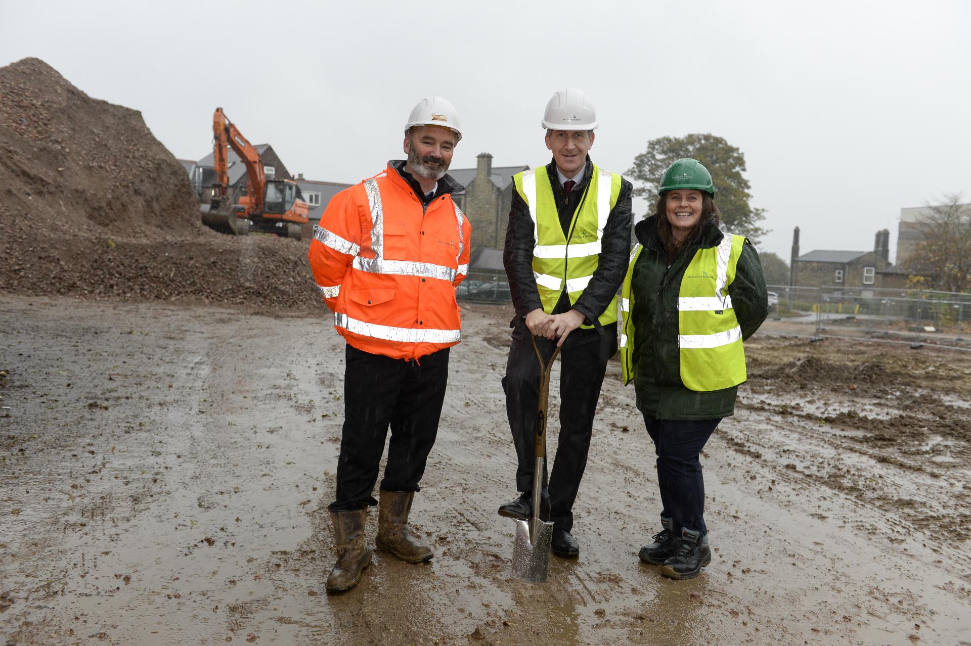 a group of men wearing safety vests and standing in a construction site