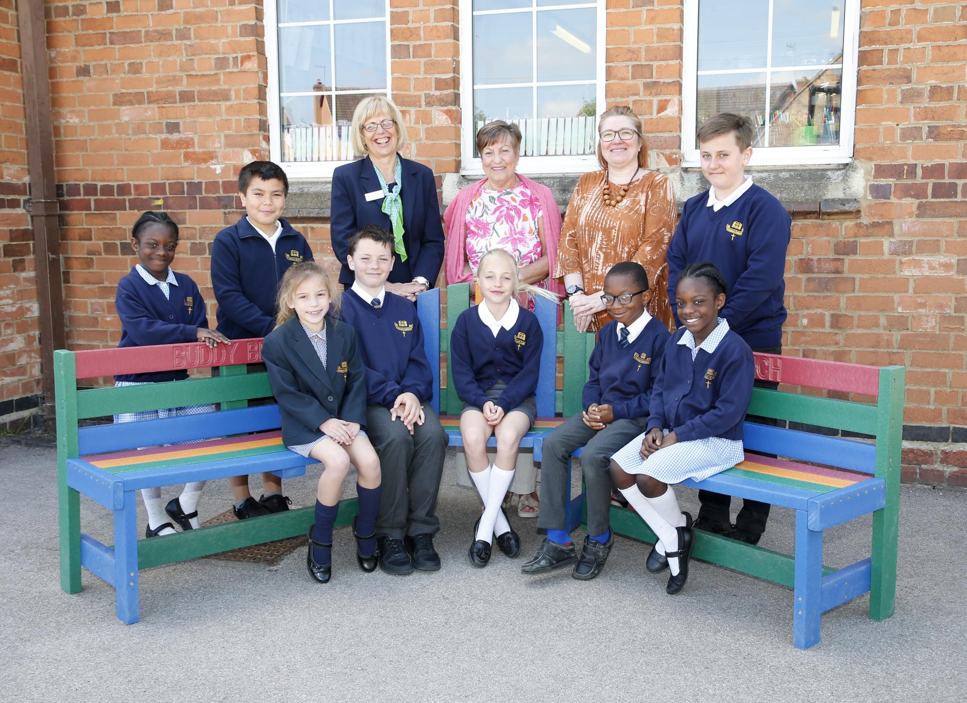 a group of people sitting on a bench outside a building