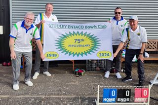 a group of men in matching t-shirts holding a banner