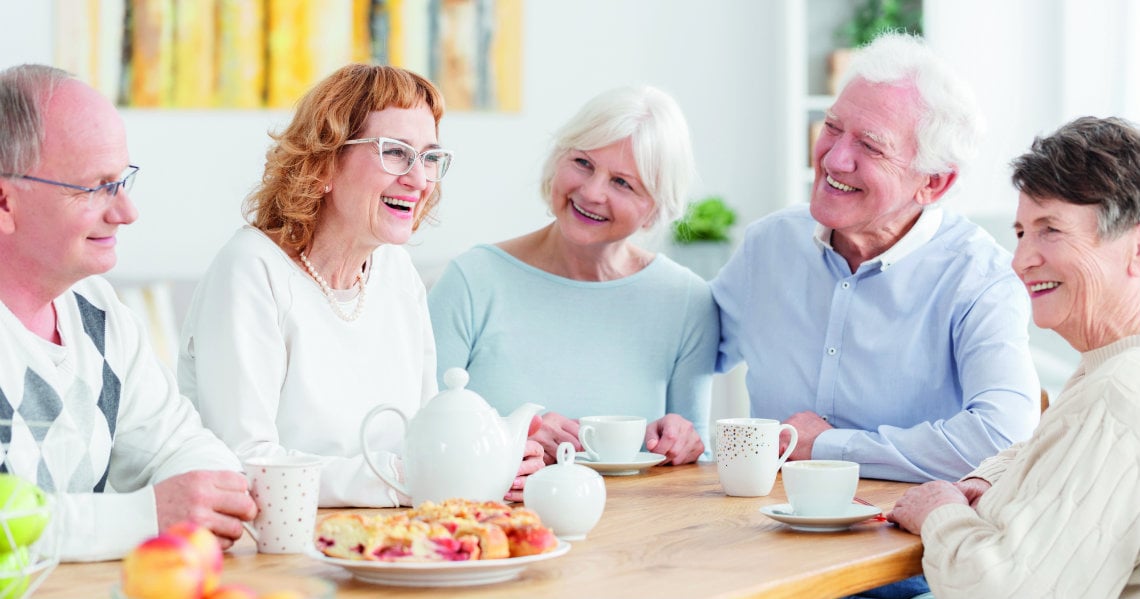 a group of people sitting around a table with food
