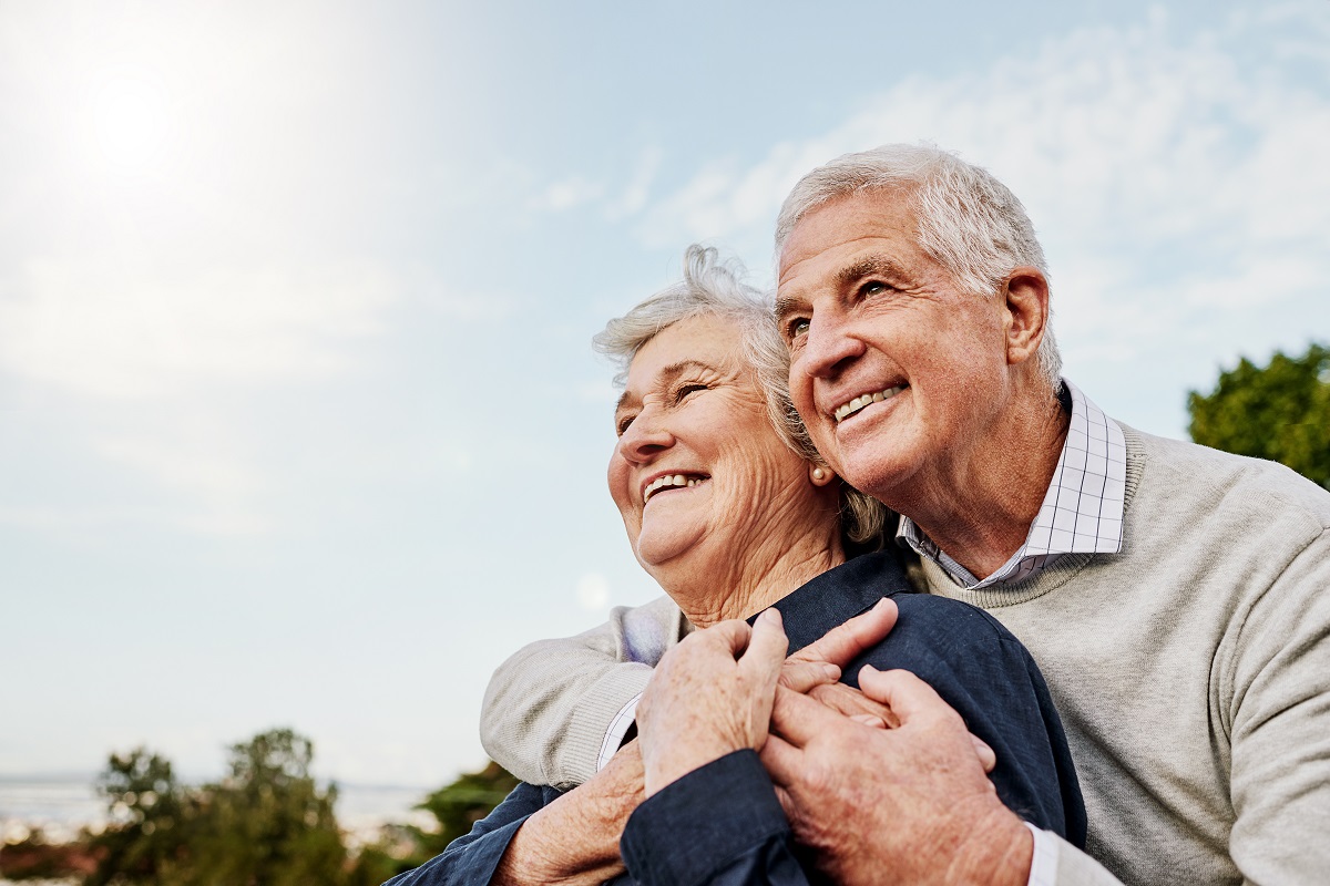 Senior couple smiling together as they enjoy the outdoors