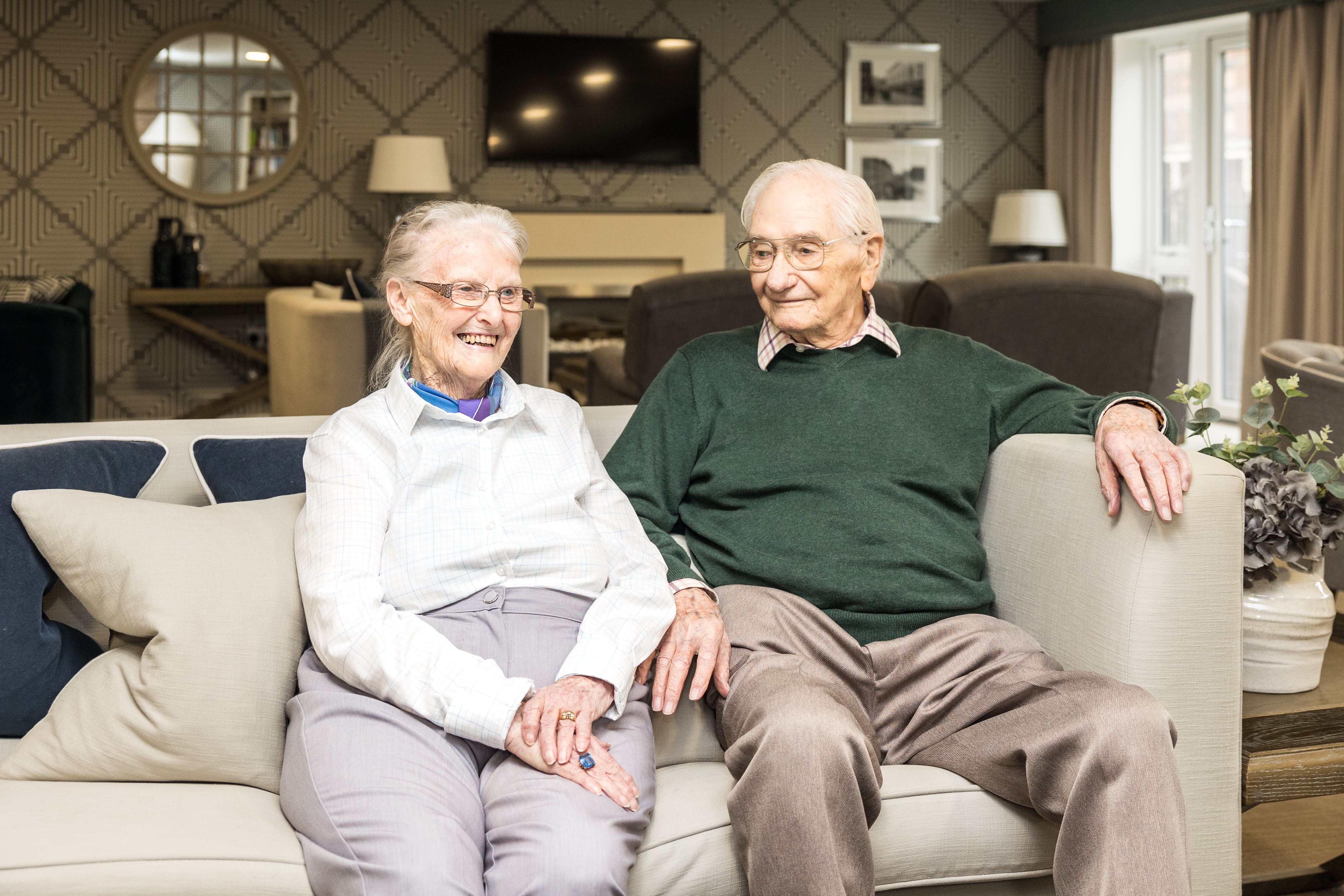 an older couple sitting on a couch