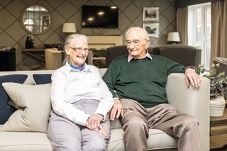 an older couple sitting on a couch
