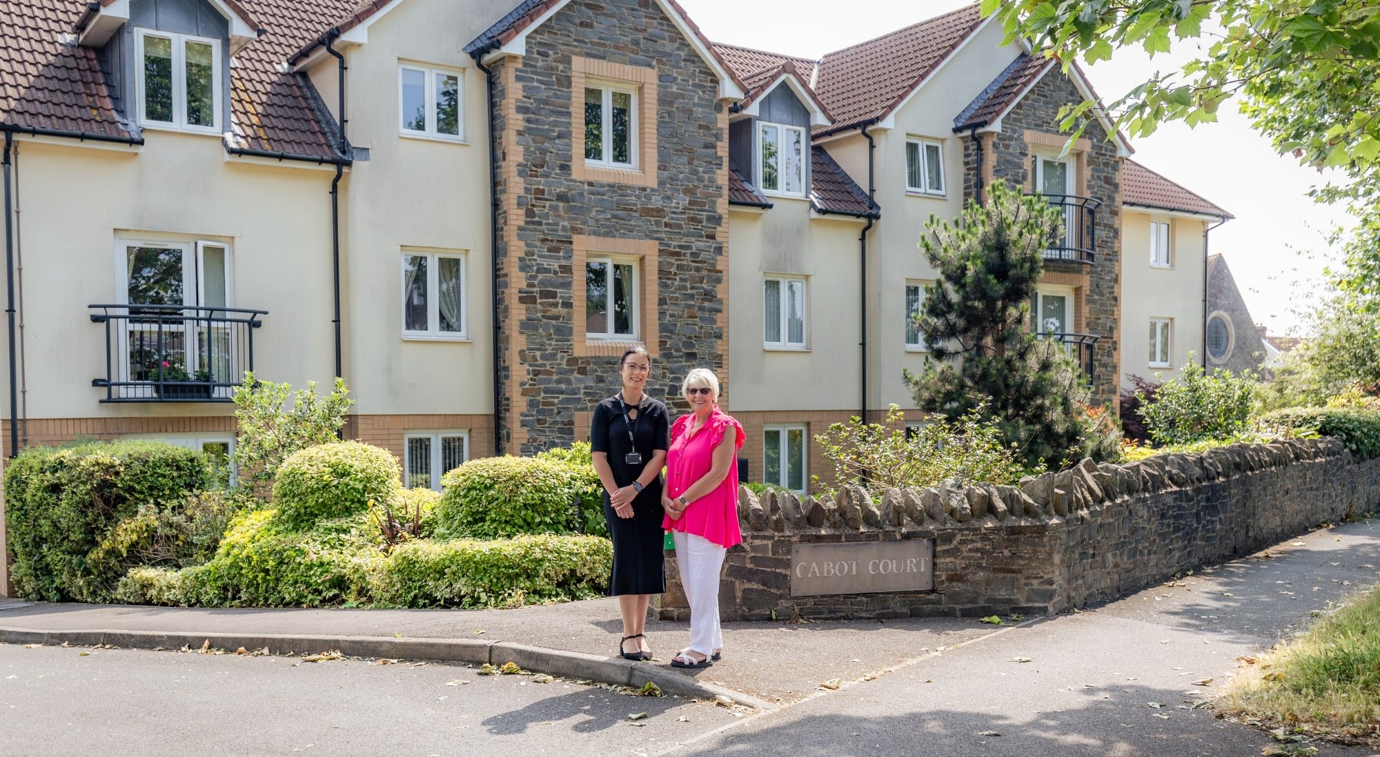Two woman standing in front of a McCarthy Stone retirement property