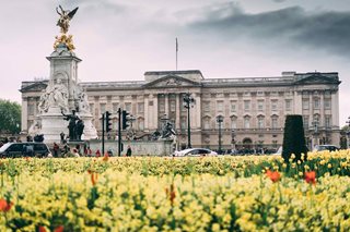 a large building with a statue in front of it with Buckingham Palace in the background
