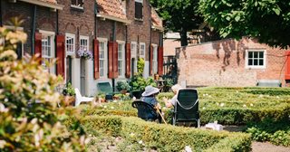 a person sitting in a chair outside a brick building