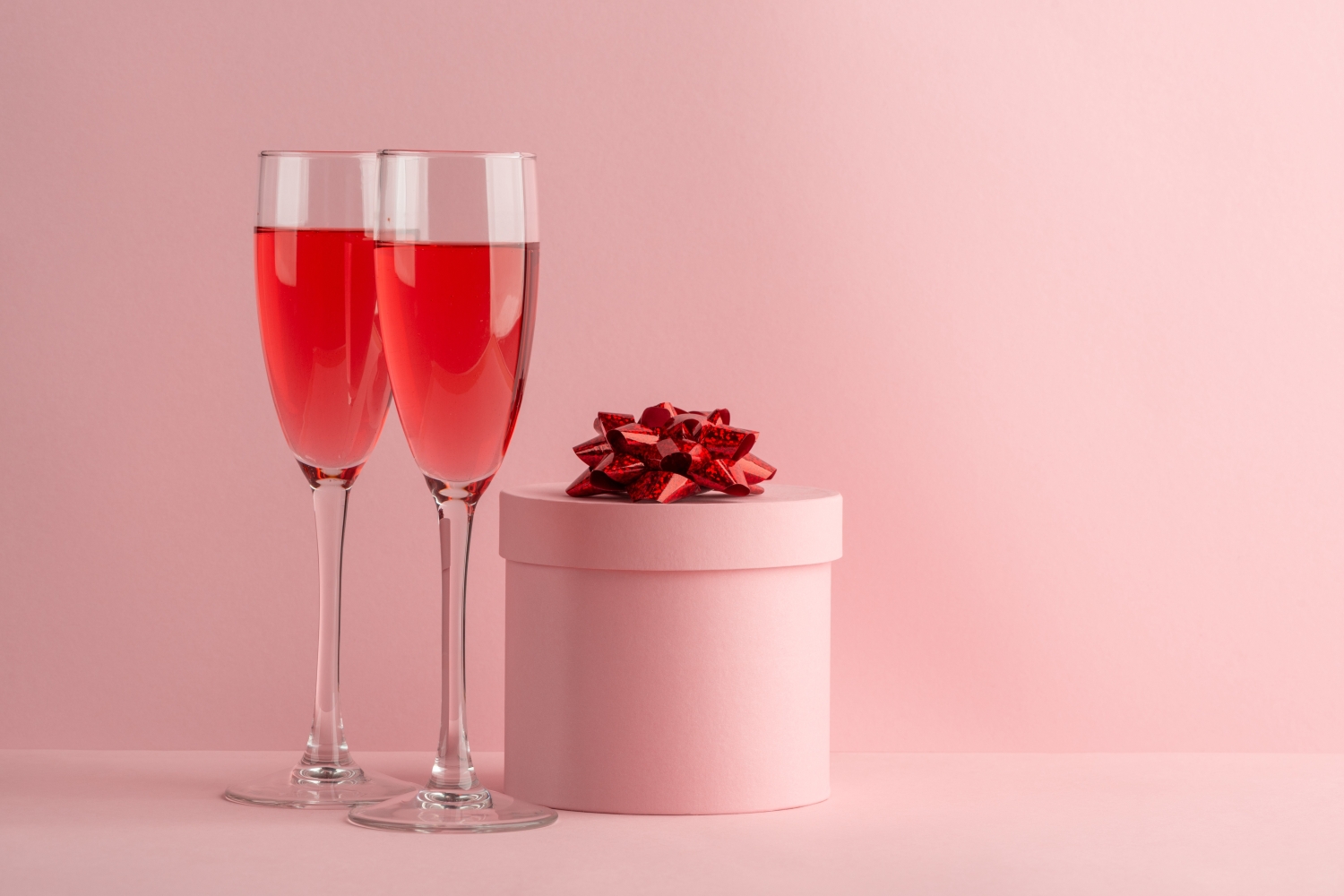Two glasses of red prosecco based cocktails next to a present.