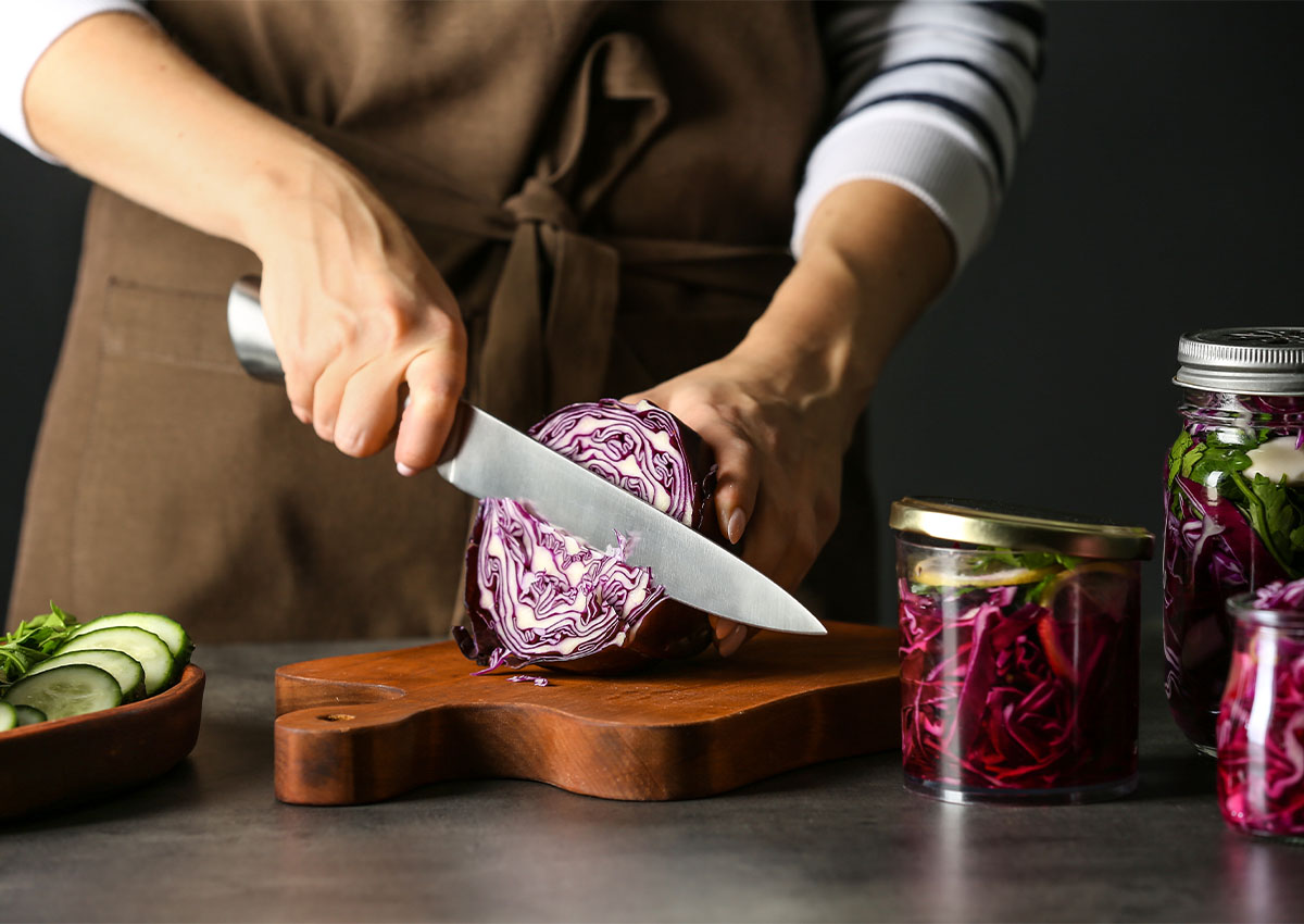 Preparing ingredients for sauerkraut on wooden chopping board