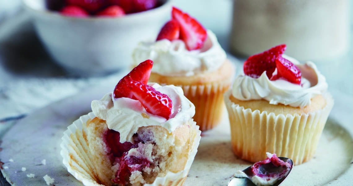 a group of cupcakes with strawberries on top