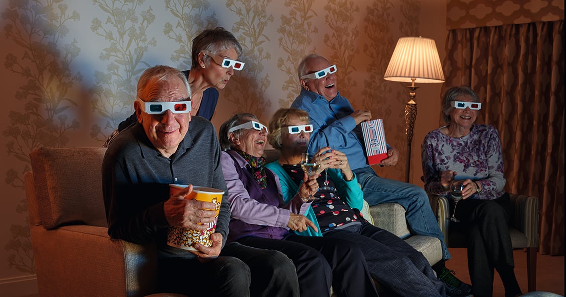 A group of people sitting on a couch and watching a film