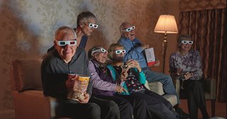 A group of people sitting on a couch and watching a film