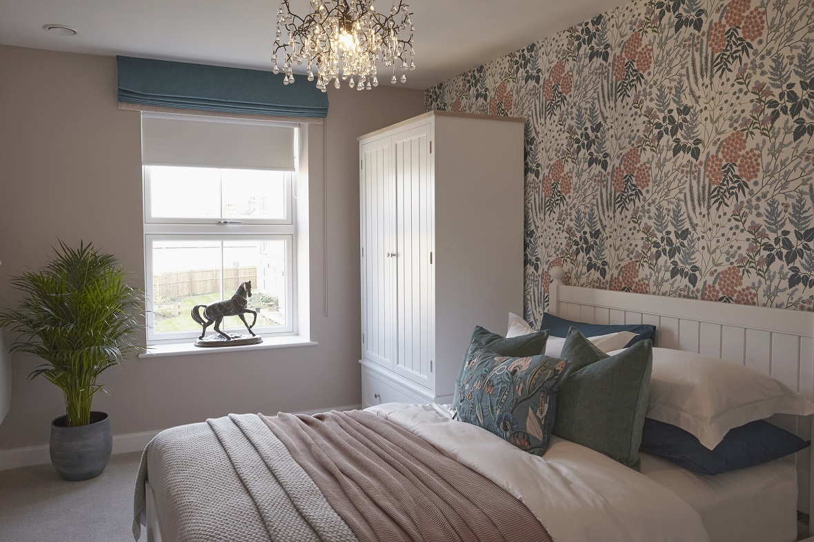 Margaret's stylish master bedroom, with horse statue on the window sill and floral wallpaper.