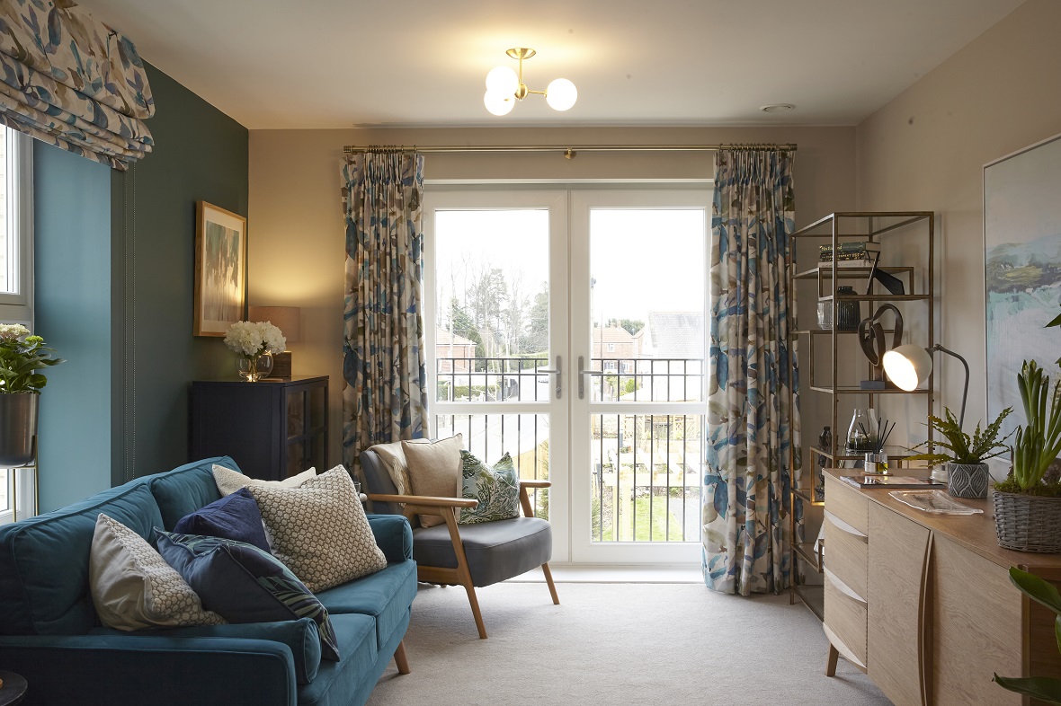 Living room with blue sofa and walls, cream cushions and floral curtains