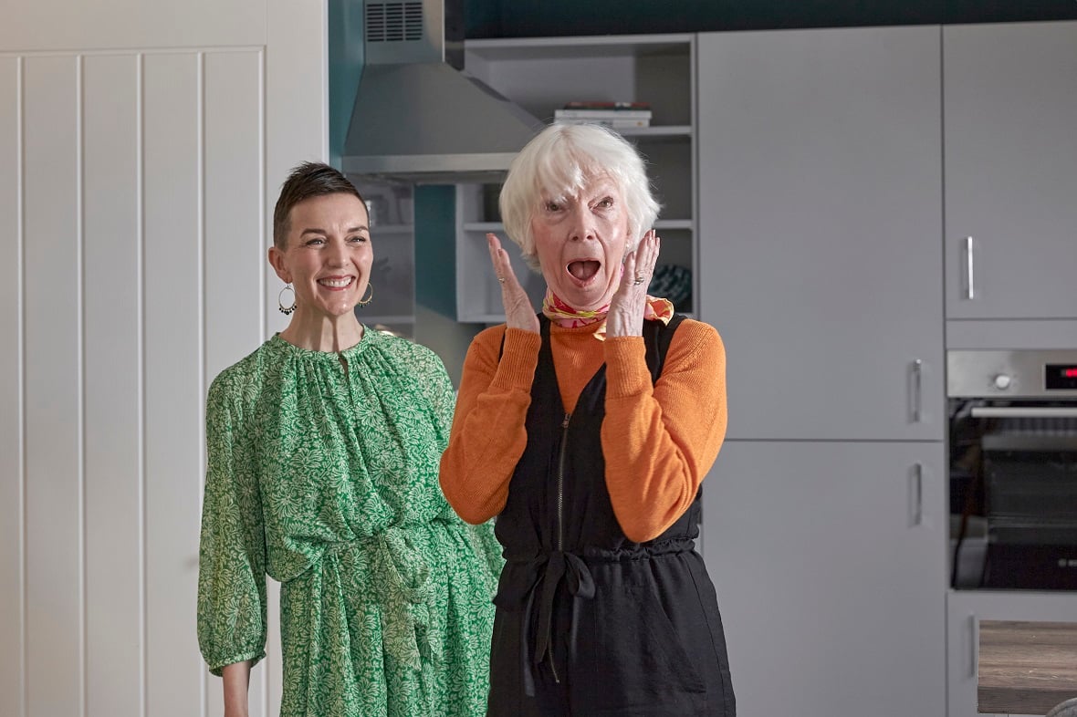 Homeowner Margaret shocked and overjoyed on first seeing her newly-designed retirement apartment, with interior designer Emma in the background.