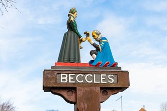 a statue of a man and woman holding hands on a pole