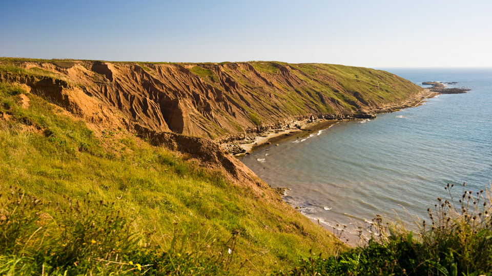 a cliff next to a body of water