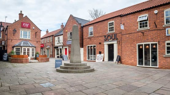 a courtyard with a fountain in front of a brick building
