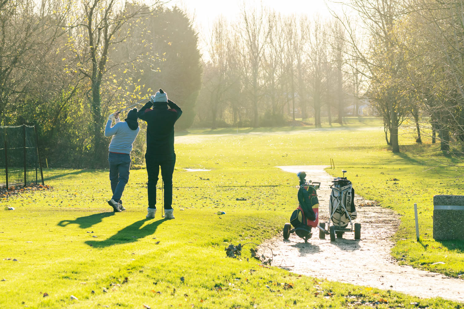 a man and woman walking with a stroller in a park