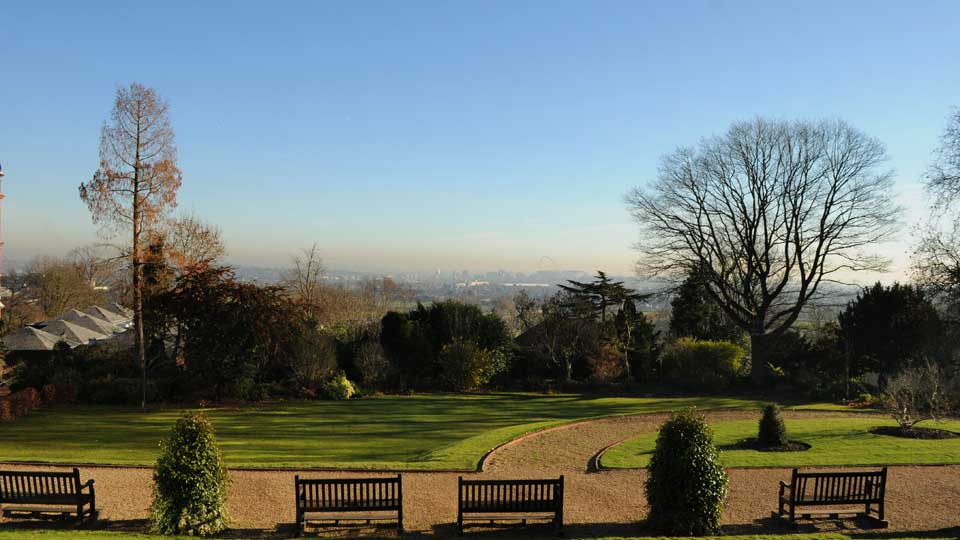 a park with benches and a view of a city
