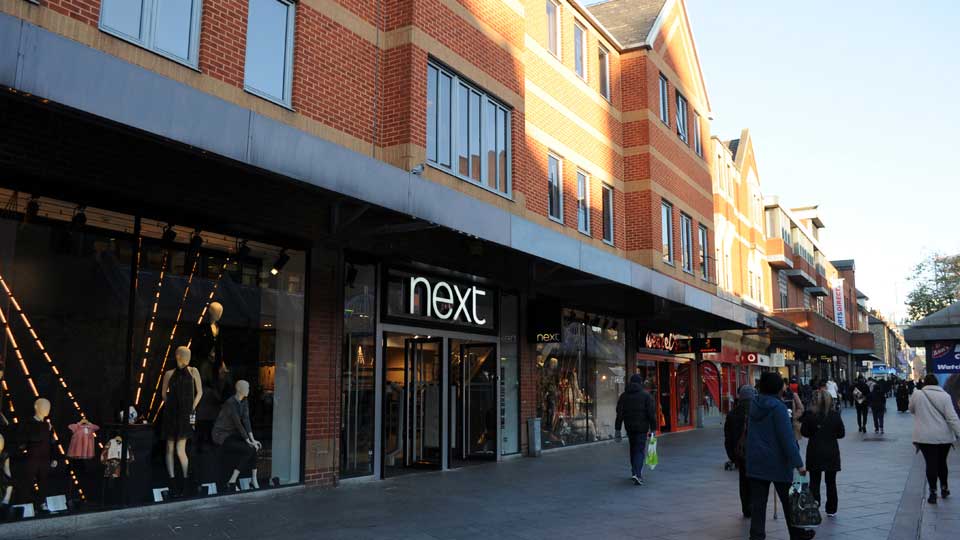 a group of people walking outside of a store