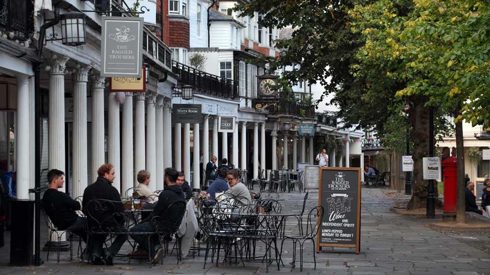 people sitting at tables outside a building