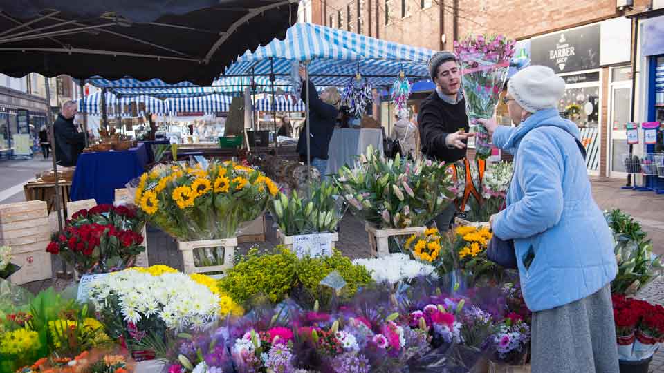 a person buying flowers at a flower market